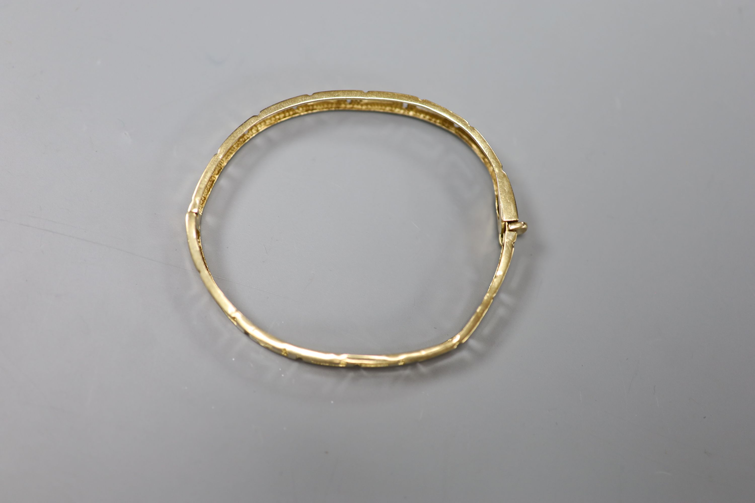 A 9ct gold Greek key design hinged bangle, 10g.